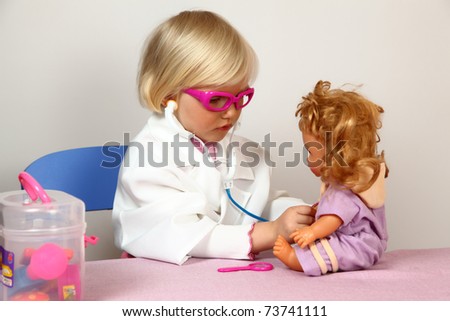 cute girl plays in doctor with doll