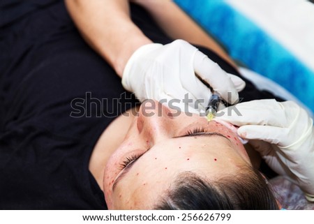 Injections on the face with cosmetic procedures , woman having beauty treatment .