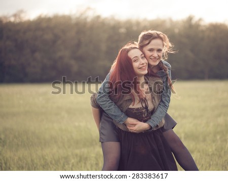 two girls making fun outdoors at sunset