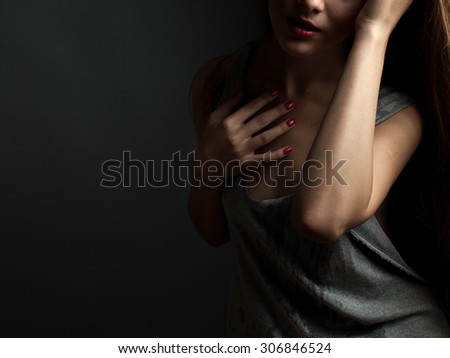Passionate young woman in a gray shirt torn. Low key