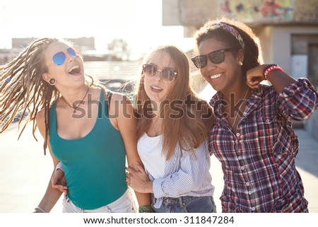 Three beautiful girls dancing and having fun on the street