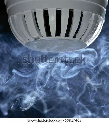 A fire detector with smoke rising.