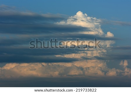 Sky and thunder clouds. Blue sky and thunder clouds in evening light and several horizontal clouds.