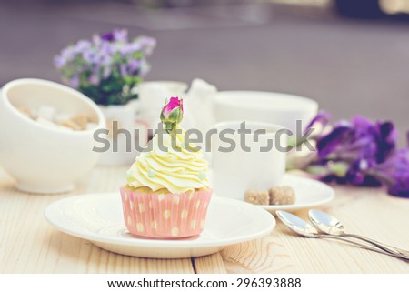 Light yellow Cupcake with rose on the table