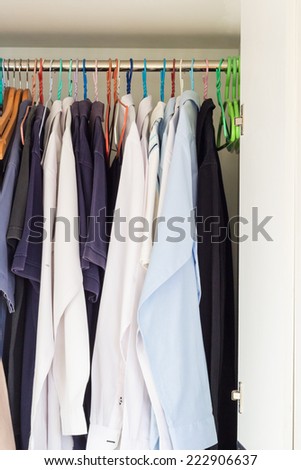 shirts hanging in man white closet