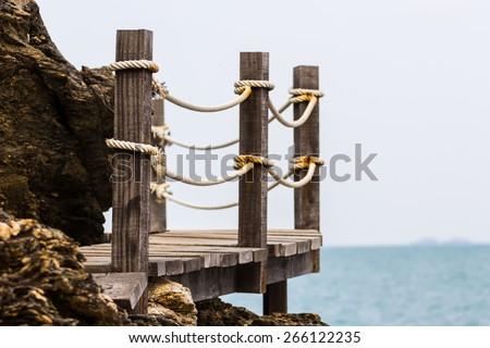 rope on wooden bridge walk path at stone cliff