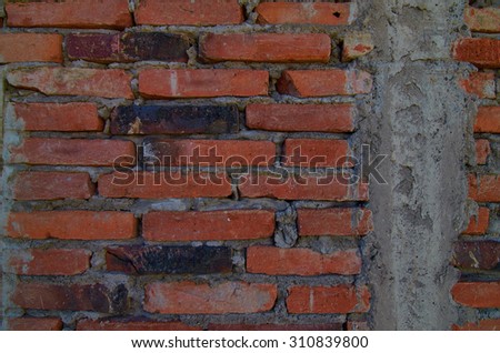 Close up of an old red brick wall.  Large gaps of mortar and imperfections in the wall