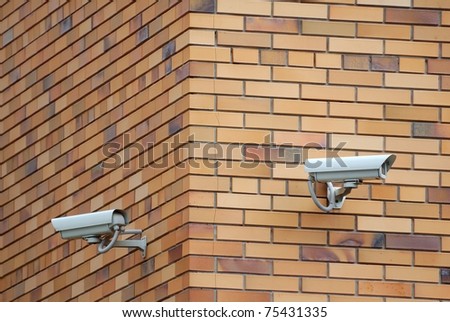 Two security cameras mounted on the facade of the building