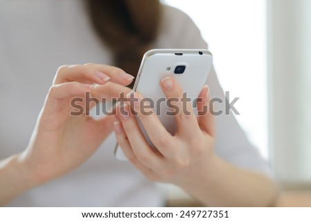 Woman Using Her Mobile Smart Phone at Home. Close-up of Mobile Phone