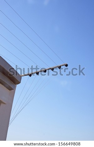 Electric fence installation on corner of concrete wall