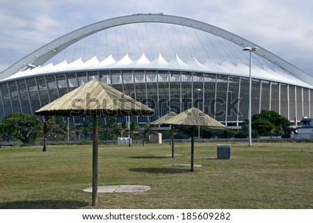 DURBAN, SOUTH AFRICA - MARCH 4, 2014: Sunshades on grassy park in front of Moses Mabhida Football Stadium in Durban South Africa
