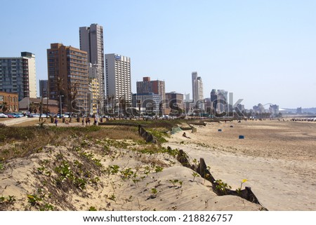 DURBAN, SOUTH AFRICA - SEPTEMBER 21, 2014: Rehabilitated sand dunes and many unknown people against city skyline in Durban, South Africa