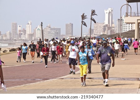 DURBAN, SOUTH AFRICA - SEPTEMBER 24, 2014:Many unknown  National Heritage Day walk participants walk along beachfront promenade in Durban, South Africa