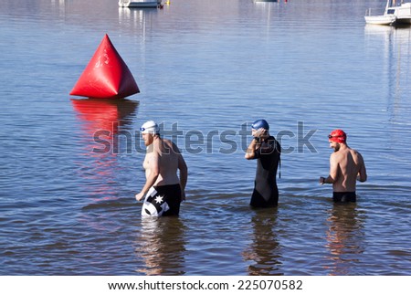 HOWICK, KWAZULU NATAL, SOUTH AFRICA - OCTOBER 19, 2014: Three unknown participants test the water before competing in the On Line Tri Series Race 1 triathlon at Midmar Dam in the Natal midlands