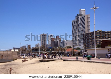 DURBAN, SOUTH AFRICA - DECEMBER 18, 2014: Many unknown people walk on promenade along North Beach against commercial and residential buildings in Durban, South Africa