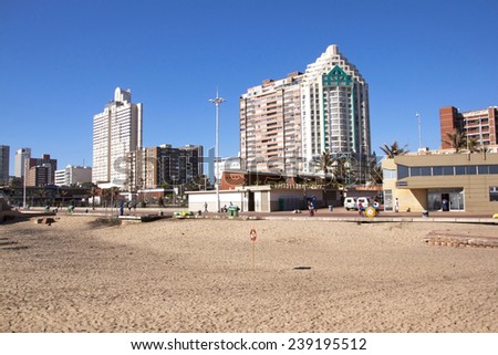 DURBAN, SOUTH AFRICA - DECEMBER 18, 2014: Many unknown people walk along promenede next to empty beach on \