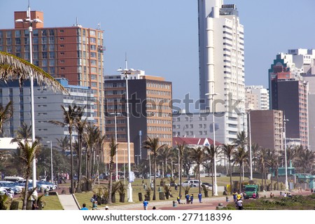 DURBAN, SOUTH AFRICA - DECEMBER 4, 2014: Many unknown people on beachfront against city skyline in Durban, South Africa