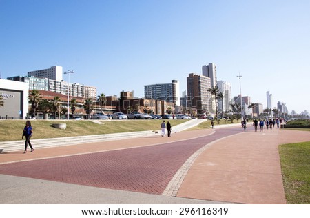 DURBAN, SOUTH AFRICA - JUNE 7, 2015: Many unknown people on early morning walk along beach front promenade in Durban, South Africa