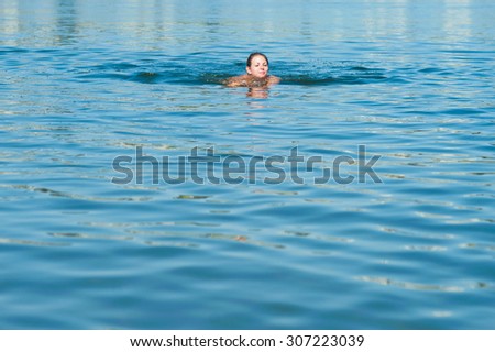 Girl swimming in blue river. summer day