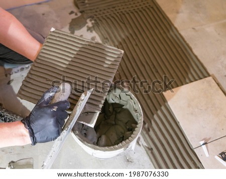 Applying thinset mortar on a tile. Apply the adhesive, closeup. Stockfoto © 