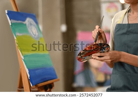 Similar – Image, Stock Photo Focused artist blending paints in palette