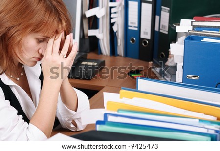 A woman looks tired, stress in office