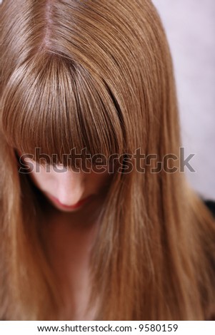 a girl with long blond beautiful lock of hair hanging down