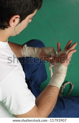 male boxer putting on white wrist wraps