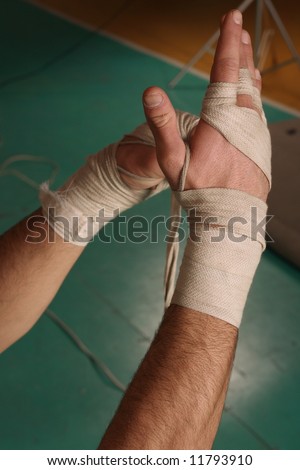 male boxer putting on white wrist wraps