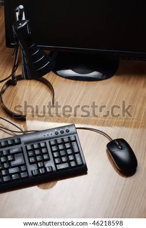 Display, lamp, computer mouse and keyboard on the desk