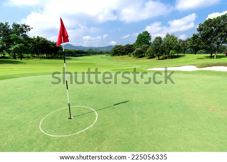 Golf course with flag and beautiful sky