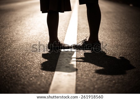 Male and female legs and shoes stand at white line street, love concept