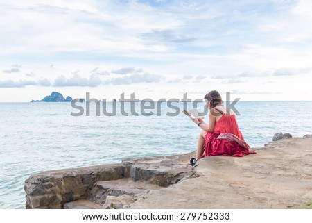 KRABI; THAILAND - May 10, 2015:woman holding a book read beside the sea. Concept of friendly family;May 10; 2015 in Krabi; thailand.
