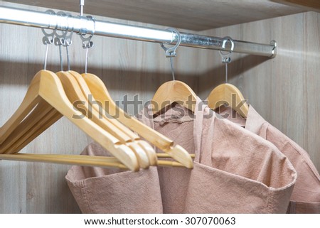bathrobe with wooden hangers in wardrobe