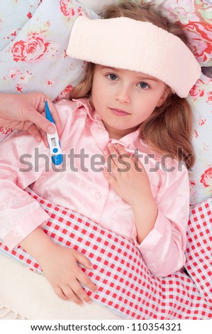 Fever, cold and flu - Mother is caring about sick child in the bed