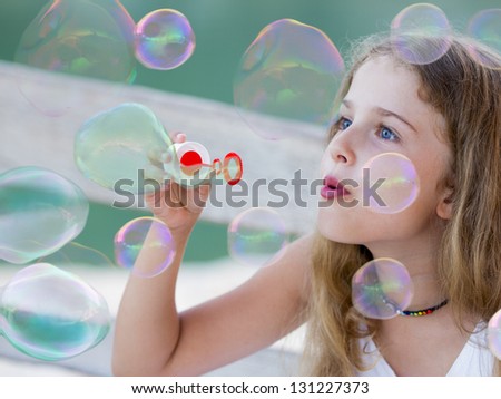Summer joy, happy child - Soap bubbles - lovely girl blowing bubbles