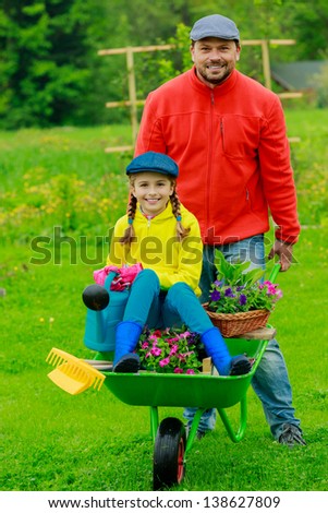 Gardening, planting - girl helping father in the garden