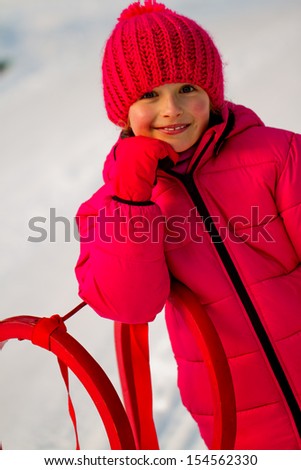 Winter play, snow, sledding - beautiful girl has a fun on snow