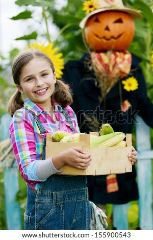 Gardening, Scarecrow and happy girl  in the garden - Autumn harvests