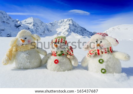 Winter, snow, sun and fun, Christmas - happy snowman friends and snowy mountains in background