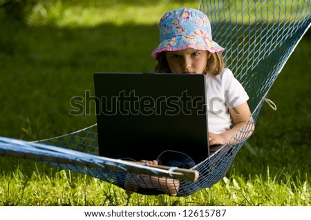 Cute girl at computer in the garden