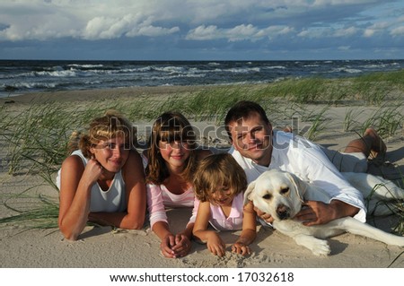 Happy family with dog on the beach