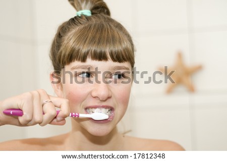Teenage girl brushing teeth in bath