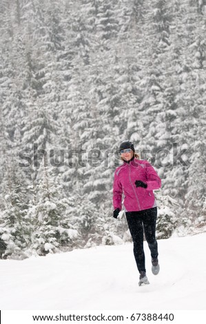 Woman running in winter forest