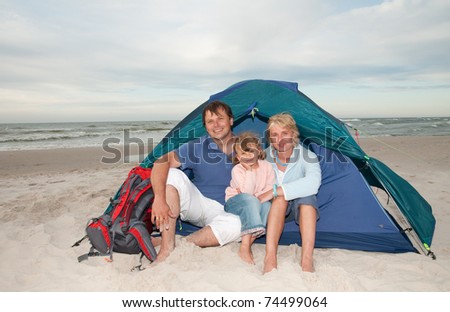 Summer vacation - family in tent on the beach