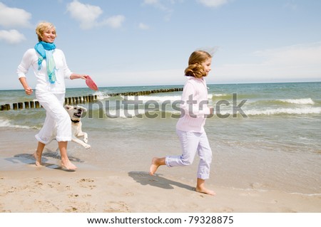 Summer vacation - family with dog playing on the beach