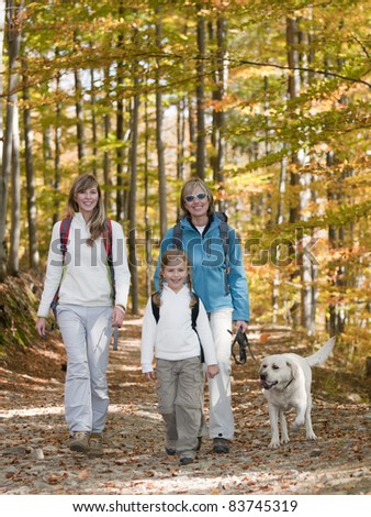Autumn walking in forest - family with dog on trek (copy space)