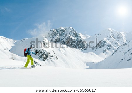 Snowshoeing - woman trekking in winter mountains (copy space)