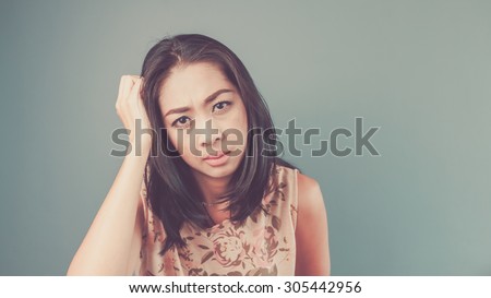 She does not understand. Vintage, retro style of portrait of Asian woman in pink vintage dress on blue - green background.