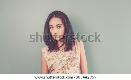 She is reading your face. Vintage, retro style of portrait of Asian woman in pink vintage dress on blue - green background.